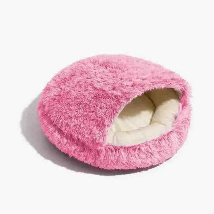Cama rosa com cobertor de algodão fofinho para cachorros e gatos, em fundo branco.