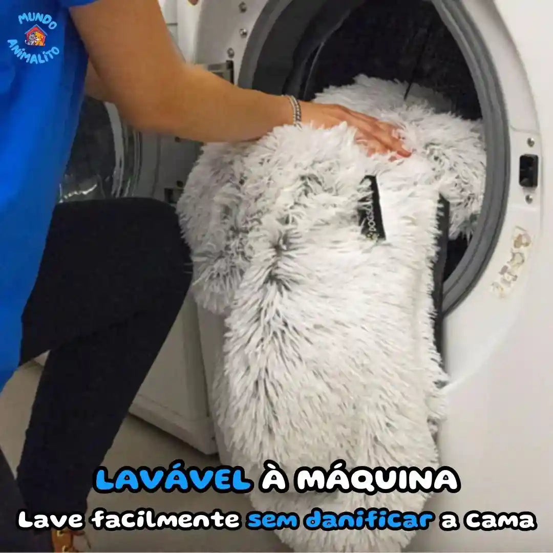 Cama redonda peluda para cachorro sendo colocada na máquina de lavar roupas.